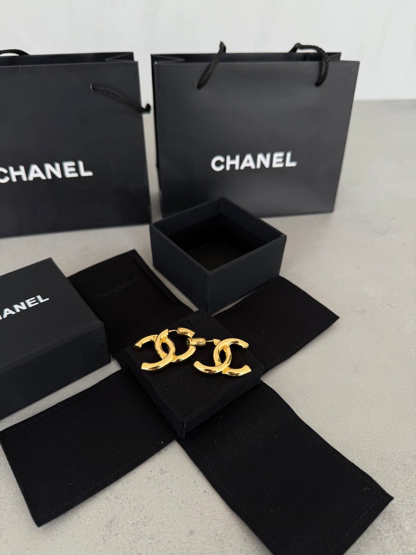 Aretes CC dorados con diseño clásico