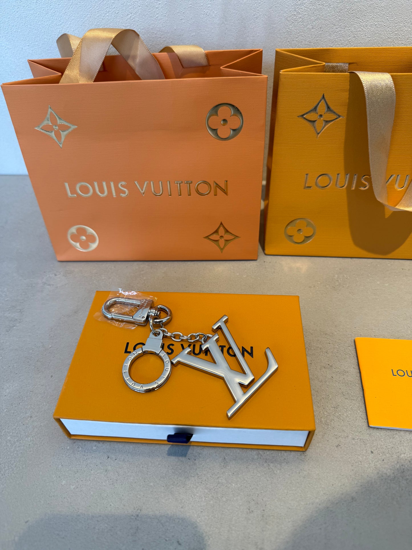 Llavero LV plateado con colgante grande del logo