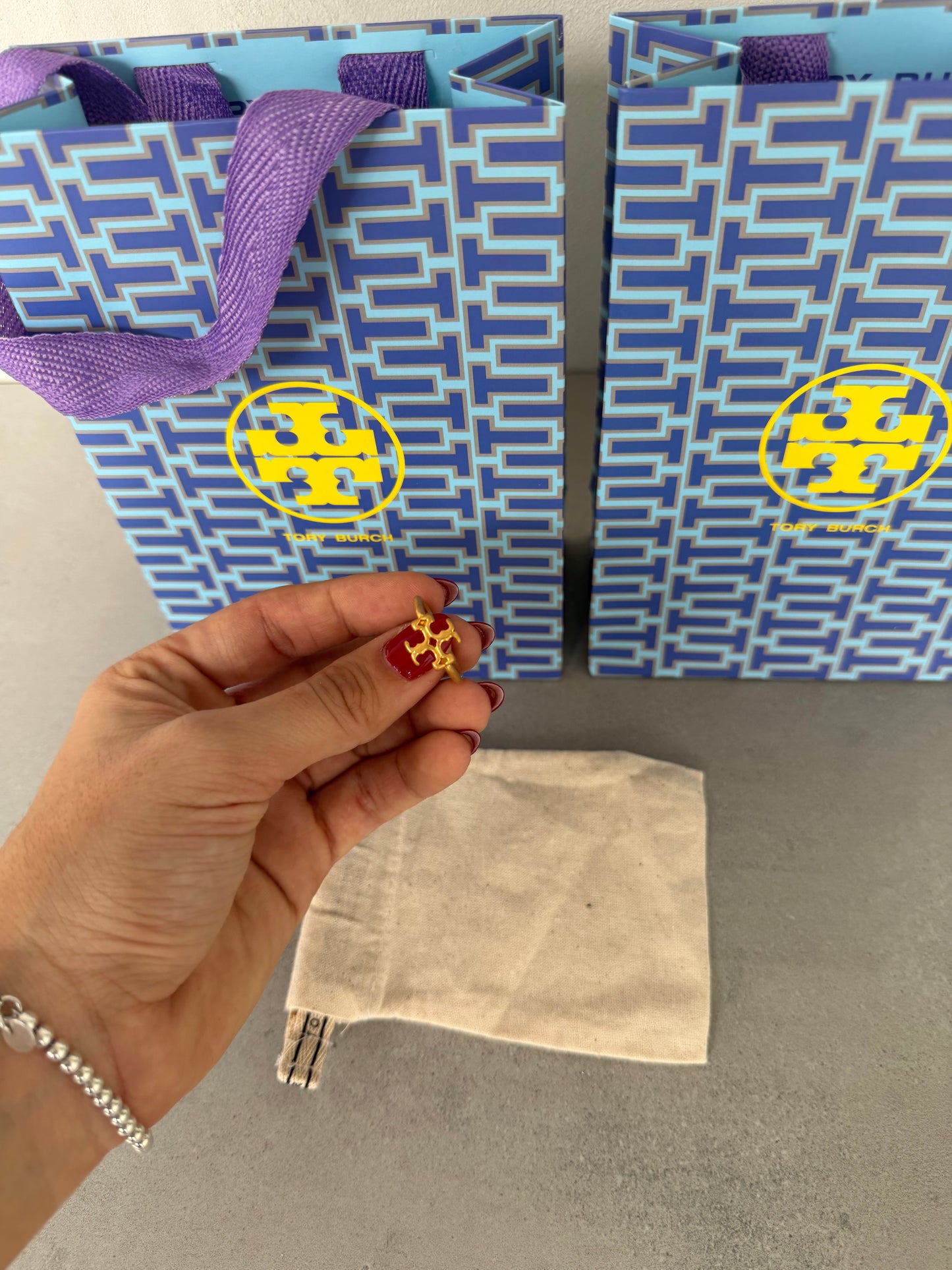 Anillo TB dorado con diseño calado en forma de emblema