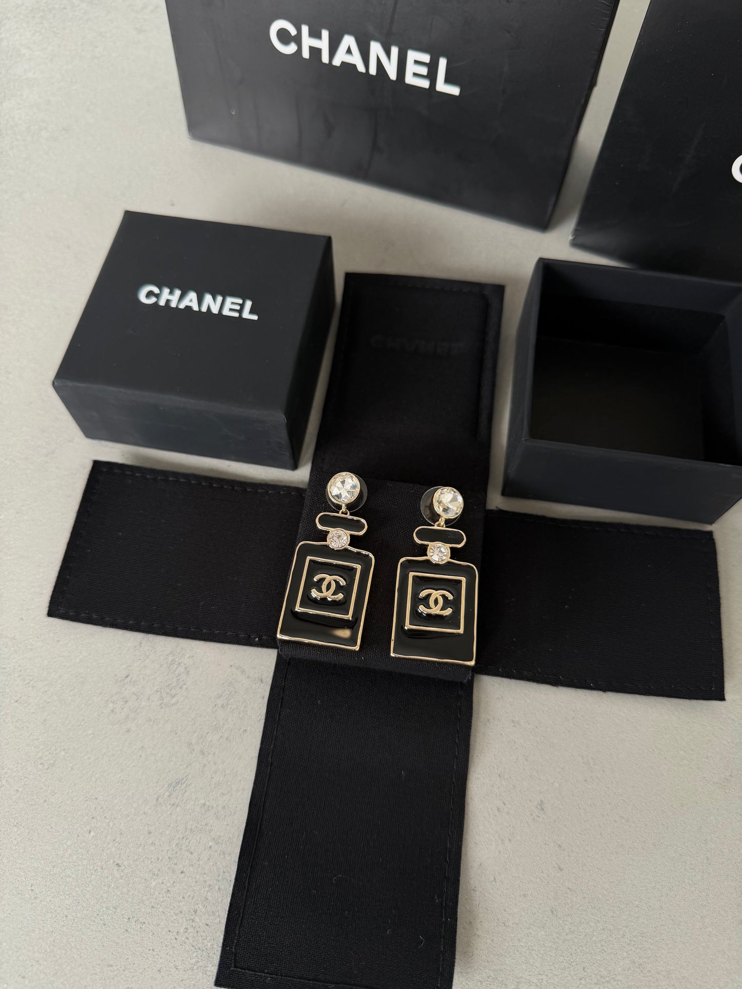 Aretes CC negro y dorado estilo perfume