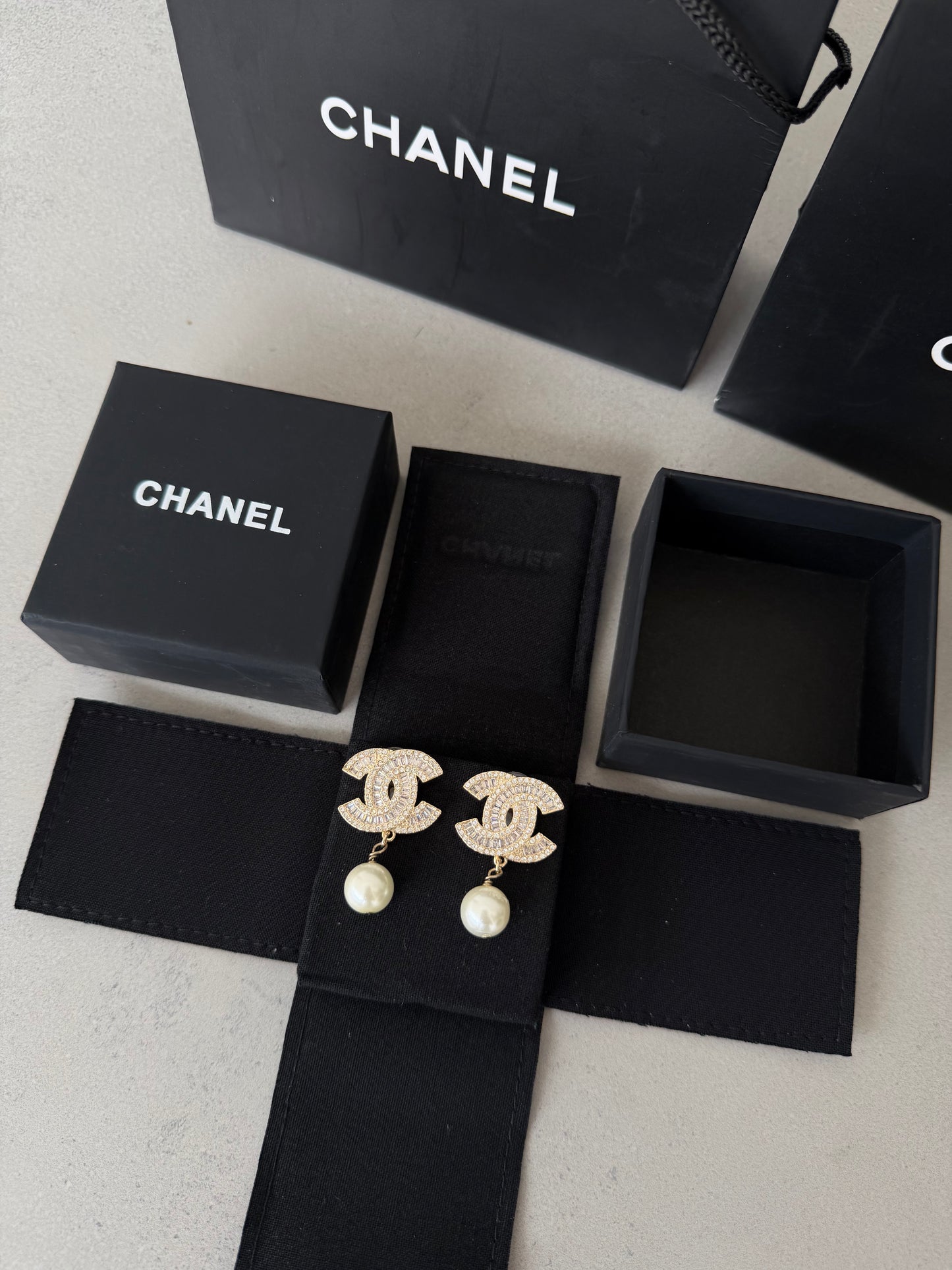 Aretes CC dorados con diamantes y perla colgante