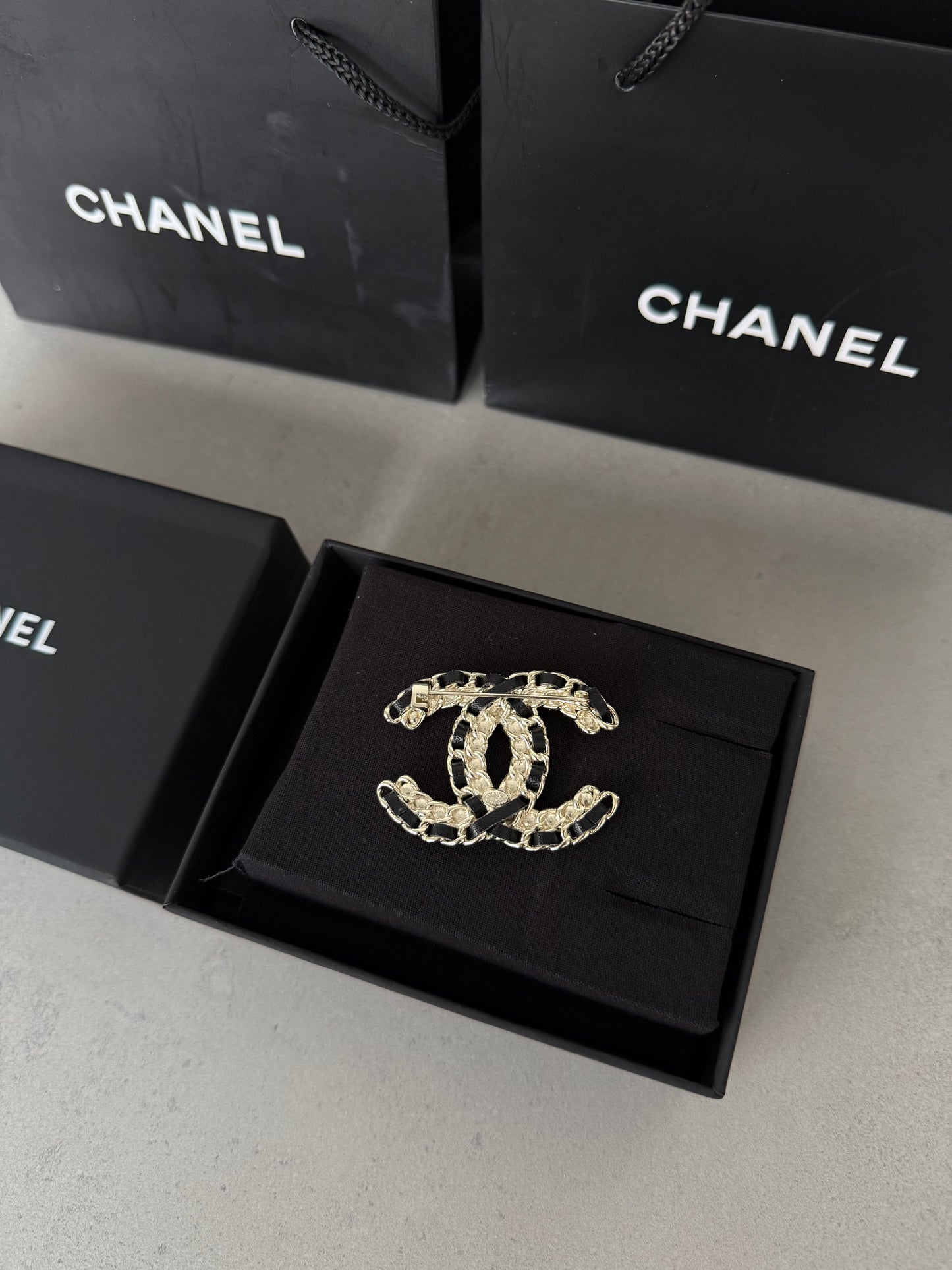 Aretes CC dorado con incrustaciones negras