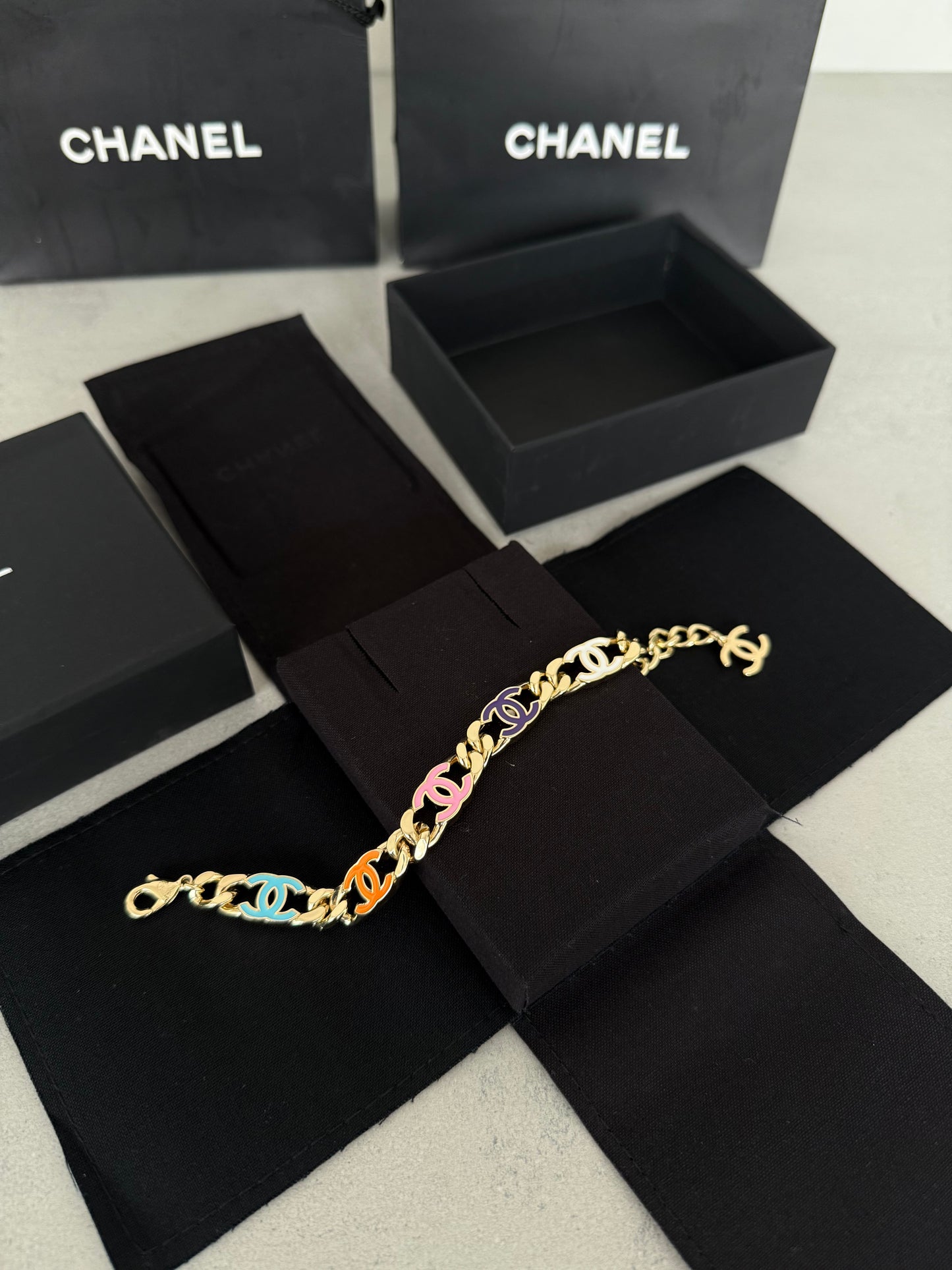 Pulsera CC dorada con logos multicolor