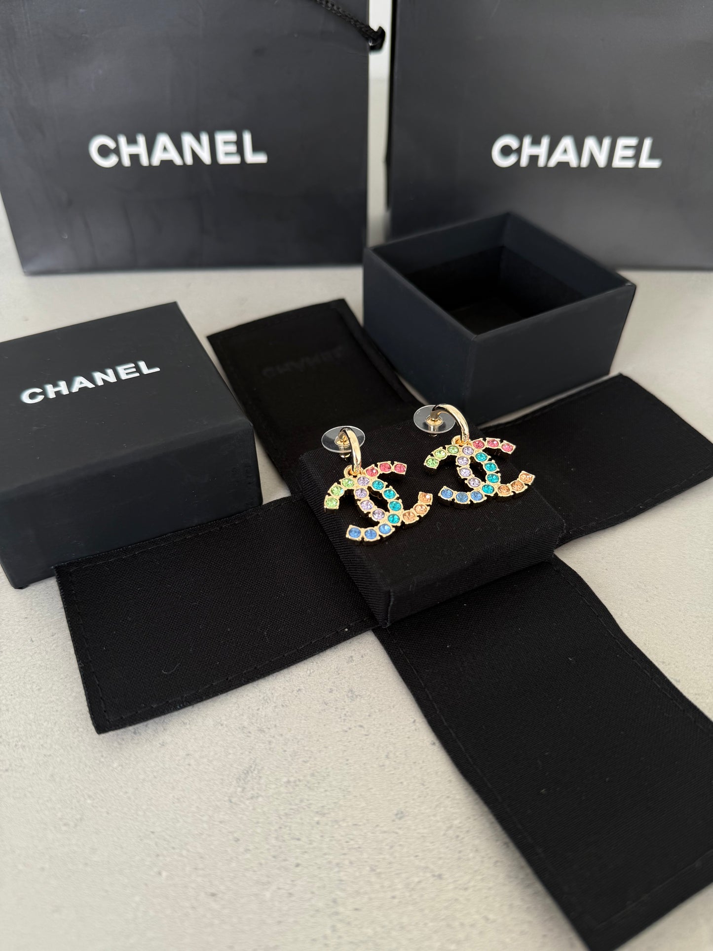 Aretes CC dorados con incrustaciones de colores