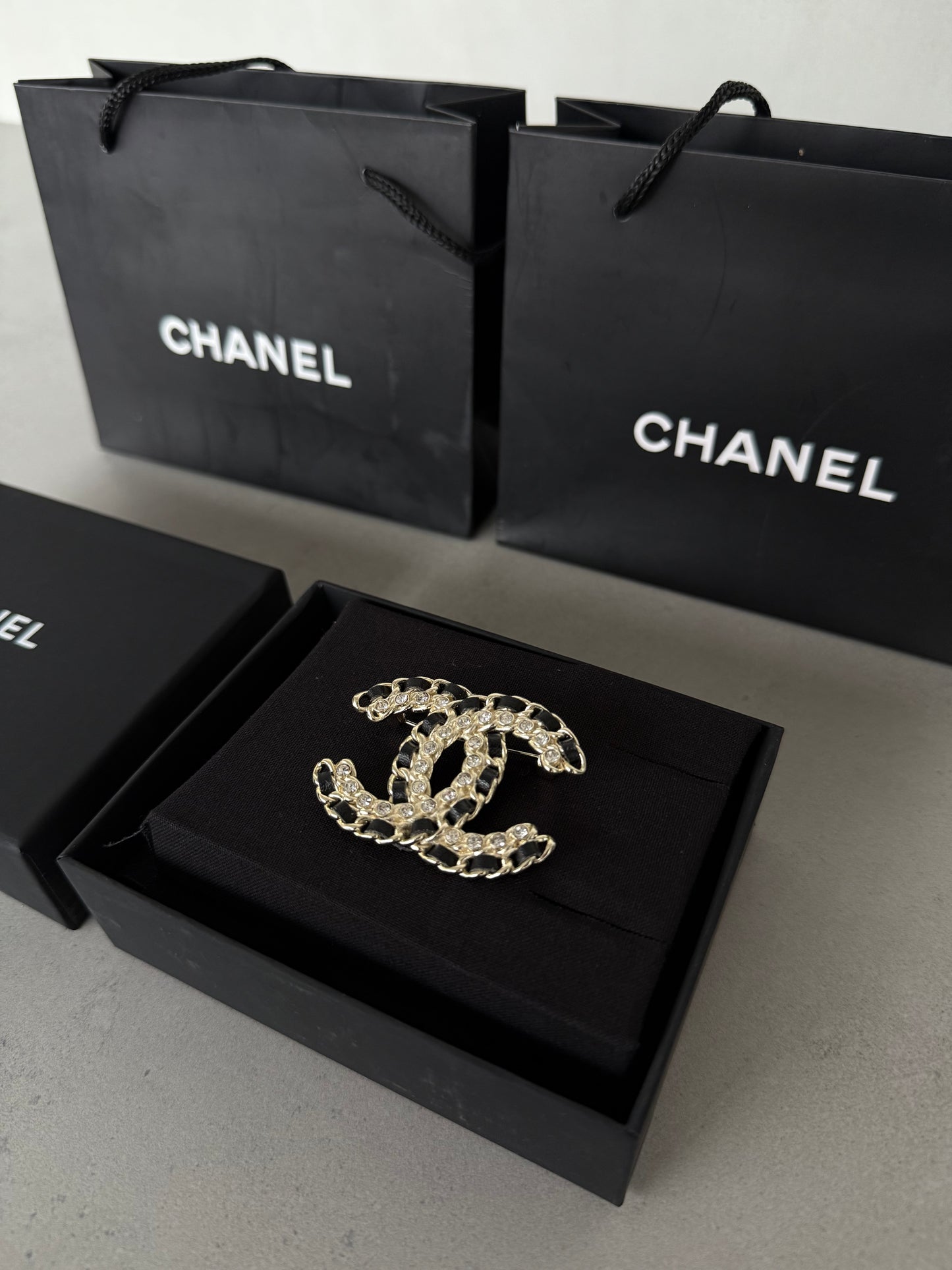 Aretes CC dorado con incrustaciones negras