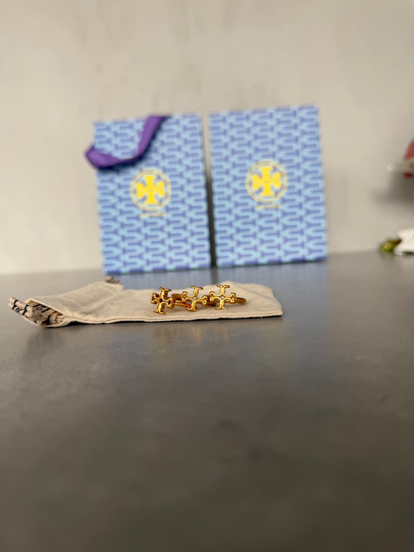 Anillo TB dorado con diseño calado en forma de emblema