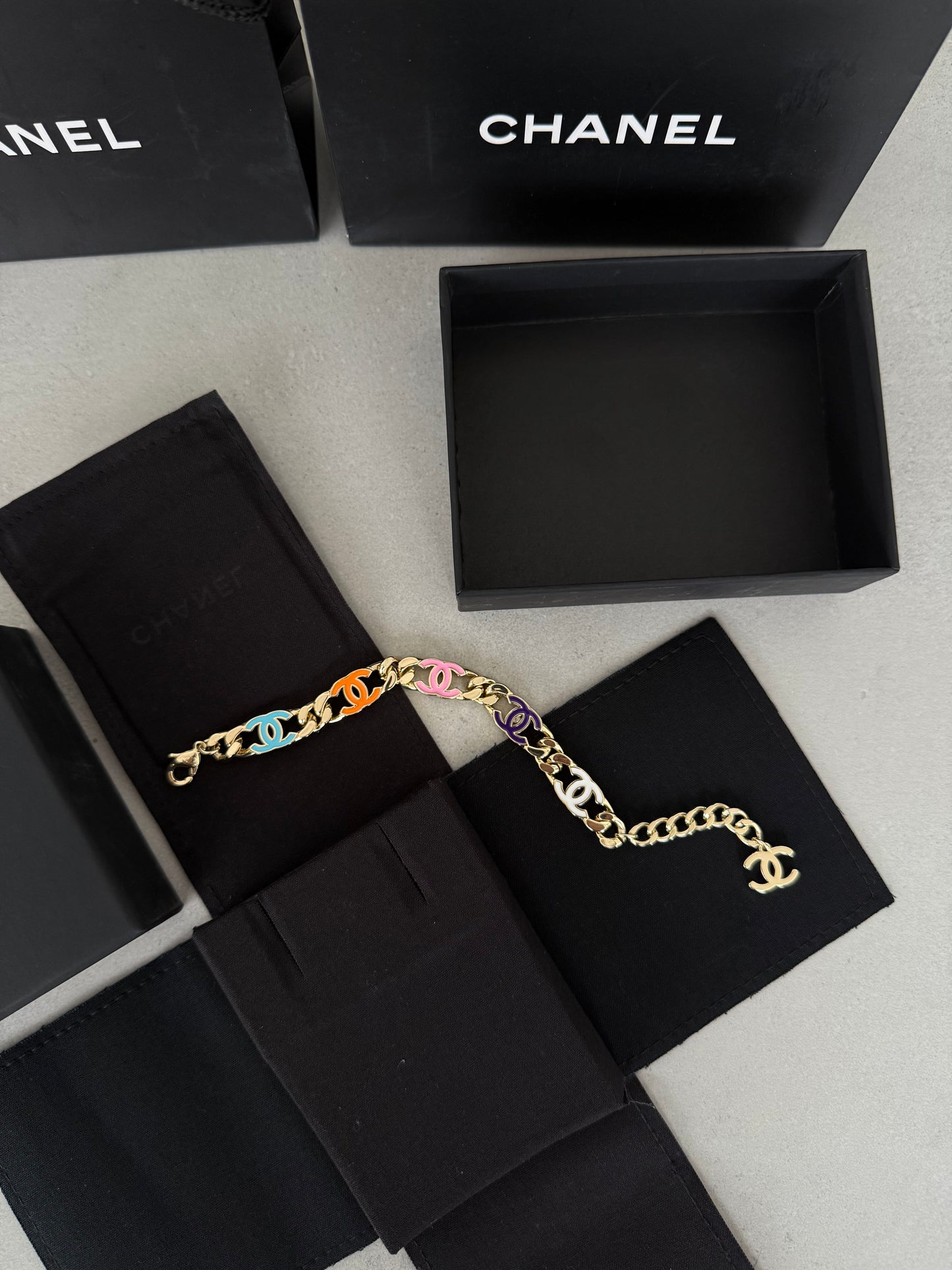 Pulsera CC dorada con logos multicolor