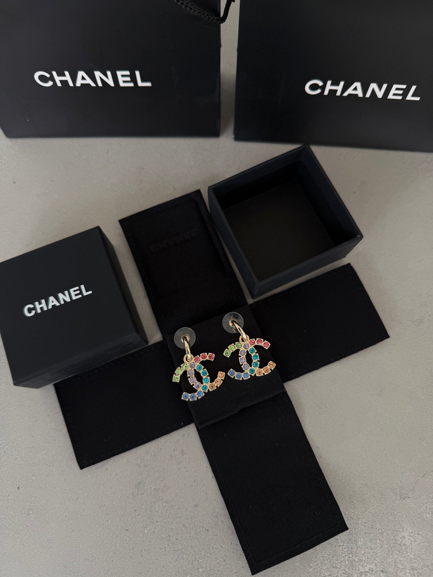 Aretes CC dorados con incrustaciones de colores
