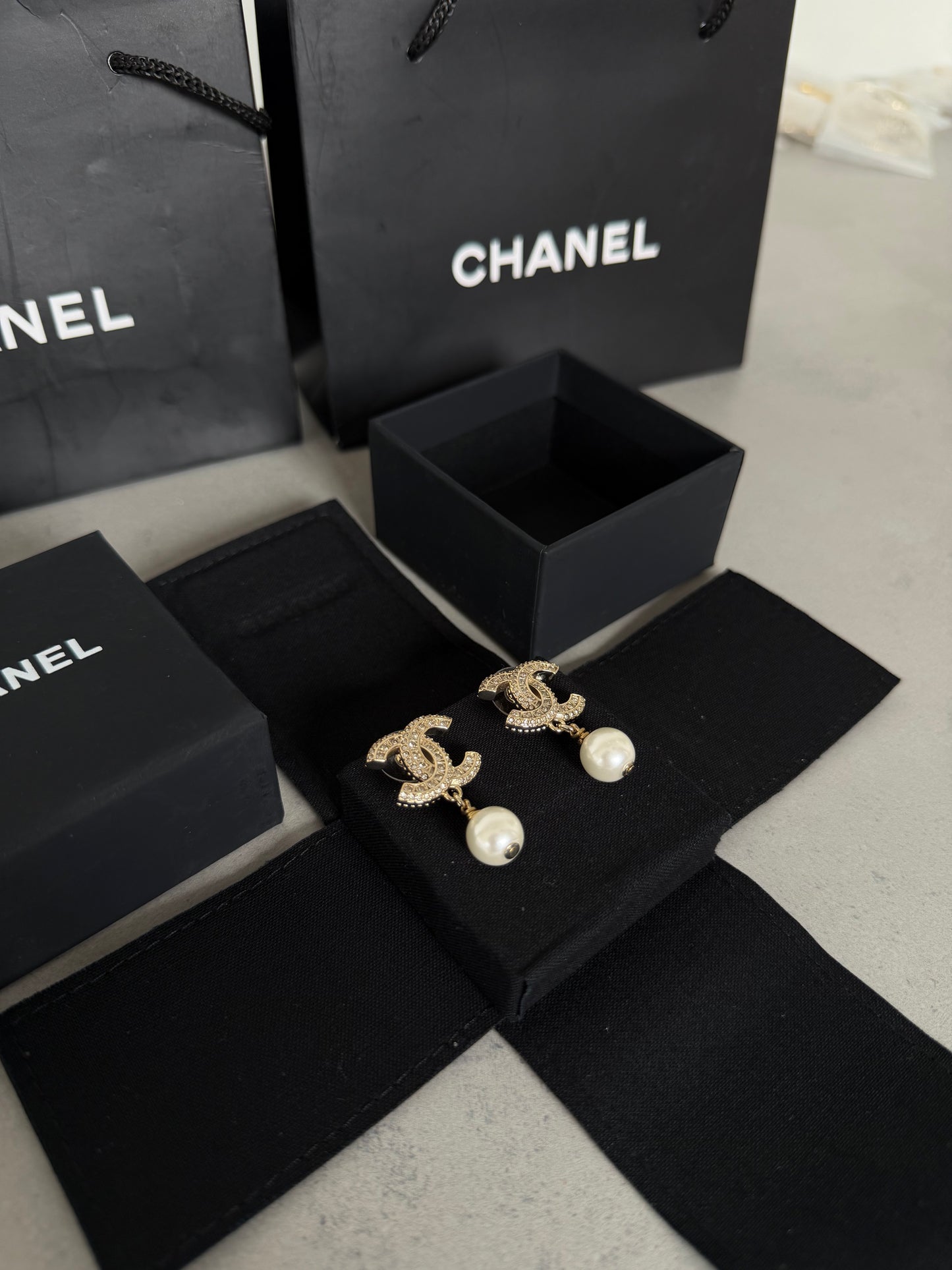 Aretes CC dorados con perla colgante