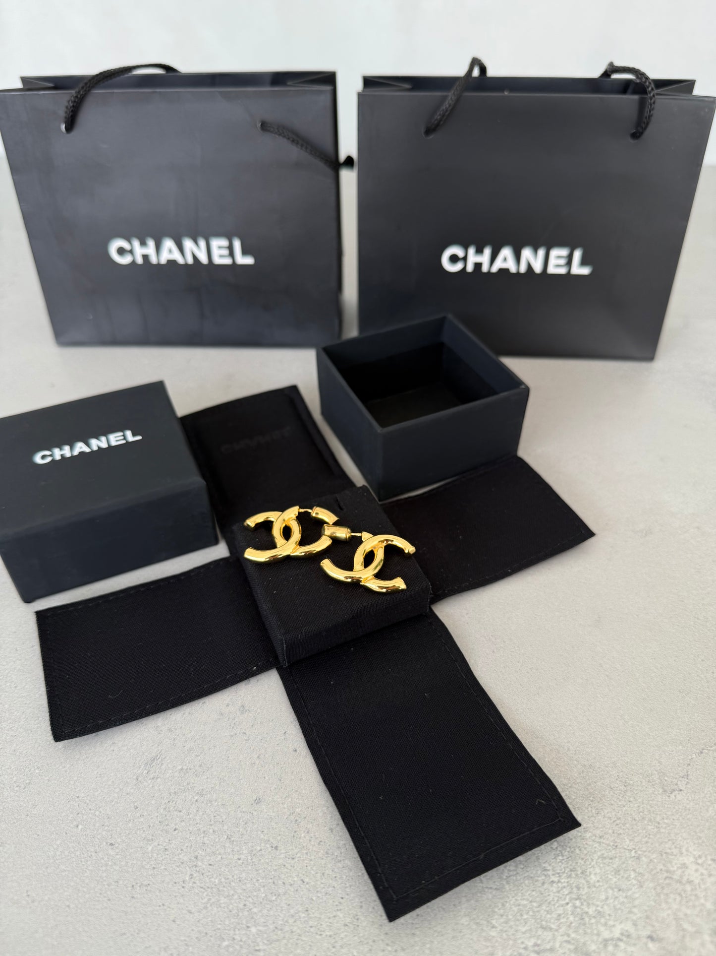 Aretes CC dorados con diseño clásico