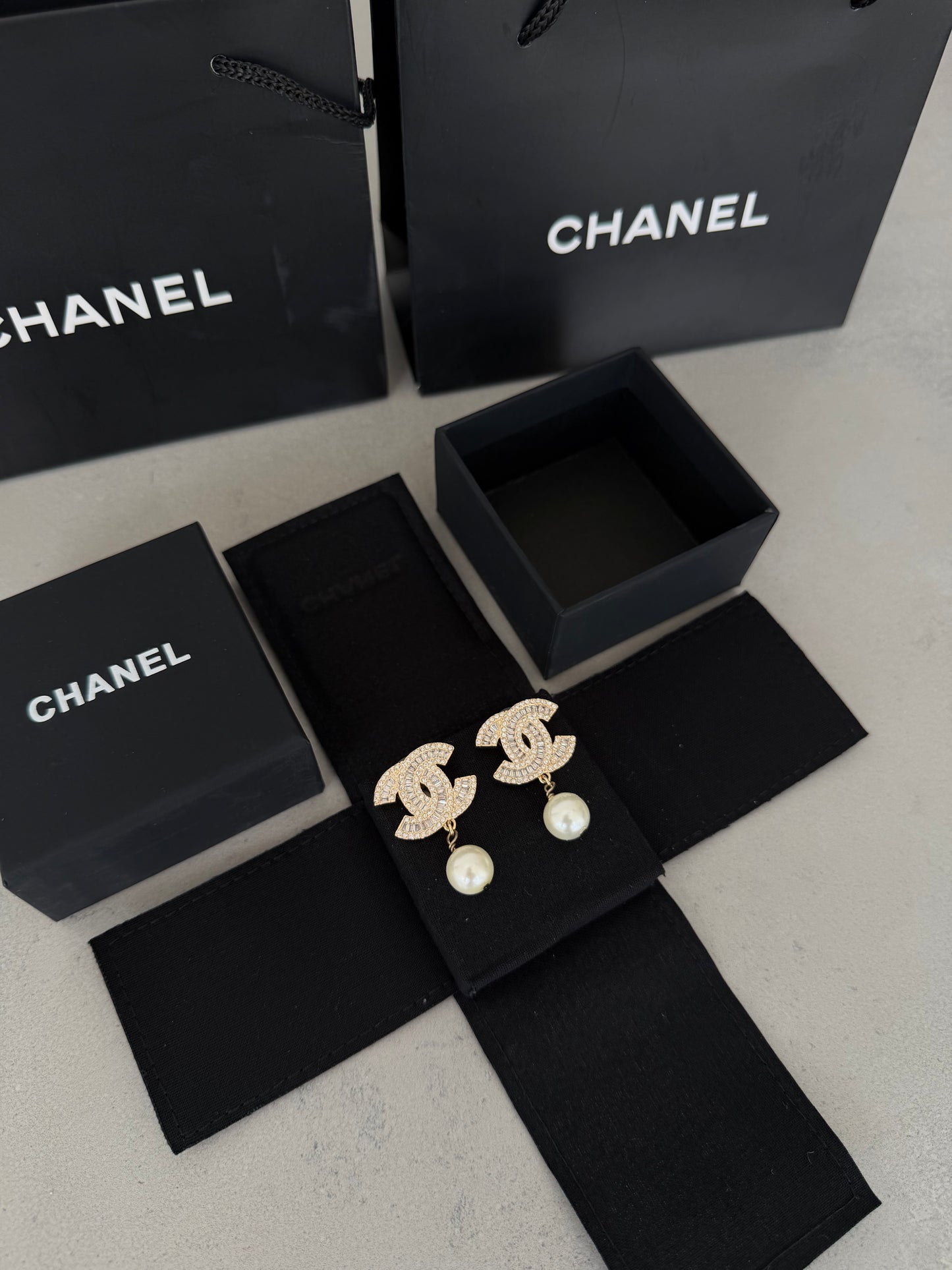 Aretes CC dorados con diamantes y perla colgante