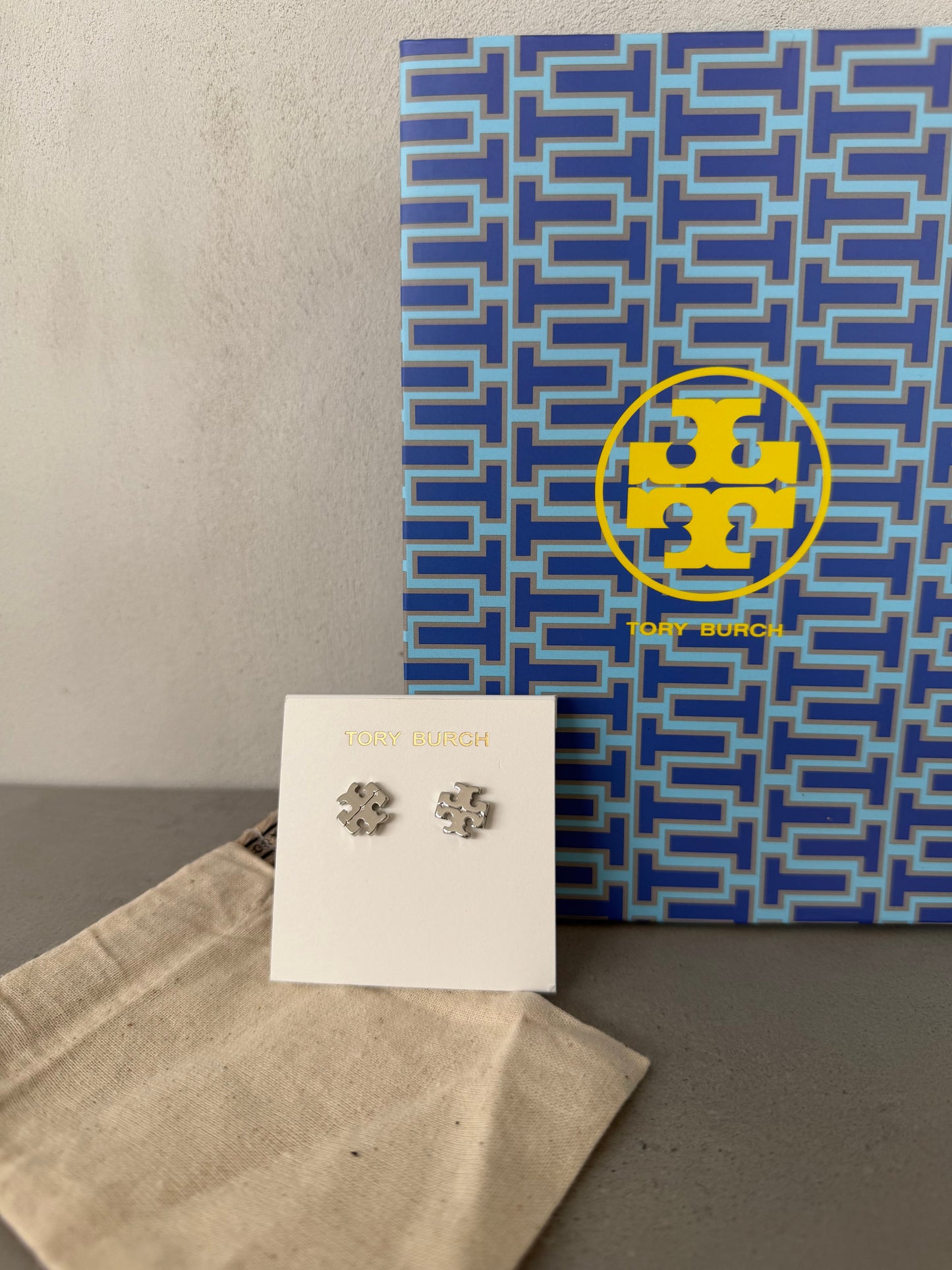 Aretes TB plateados pequeños con logo calado