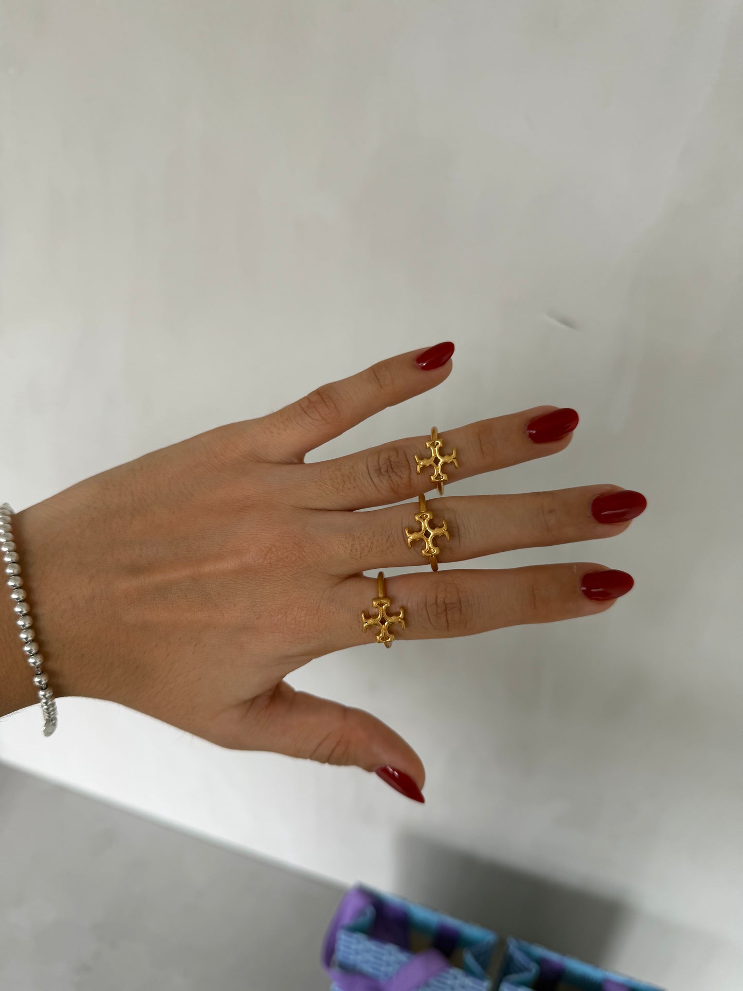 Anillo TB dorado con diseño calado en forma de emblema