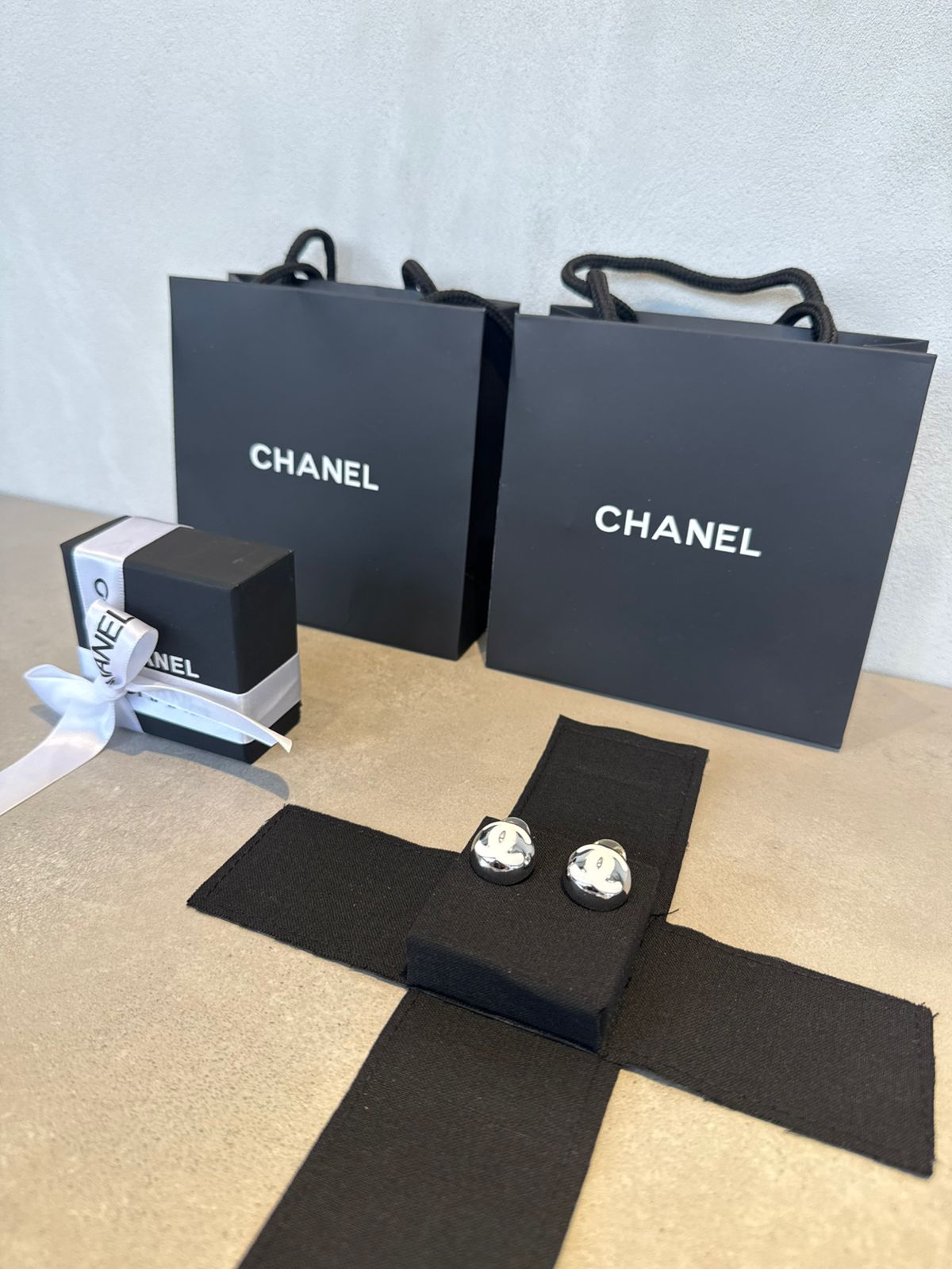 Aretes CC plateados y logo blanco 5640