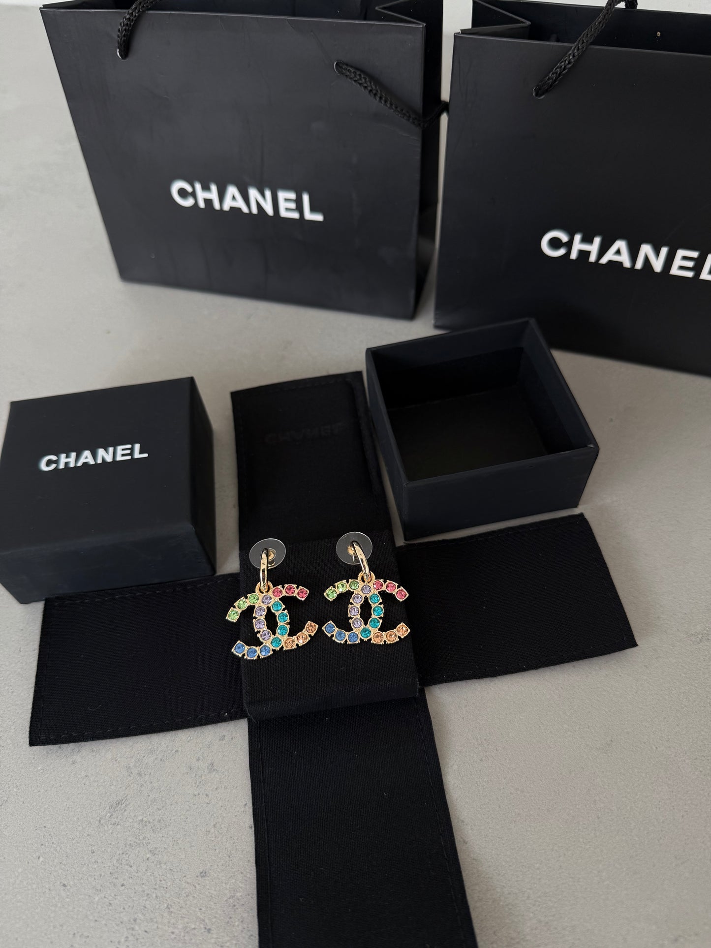 Aretes CC dorados con incrustaciones de colores