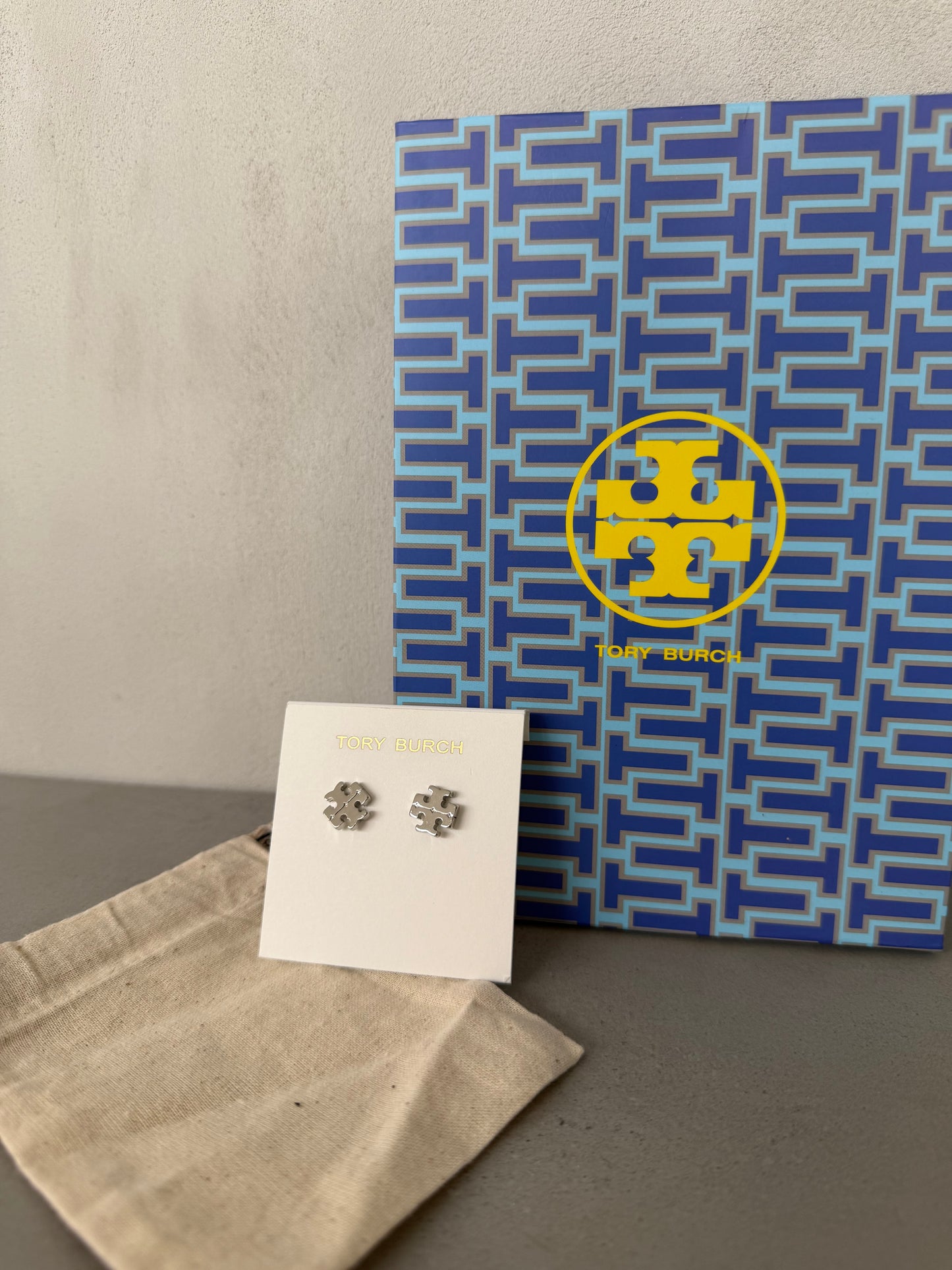 Aretes TB plateados pequeños con logo calado