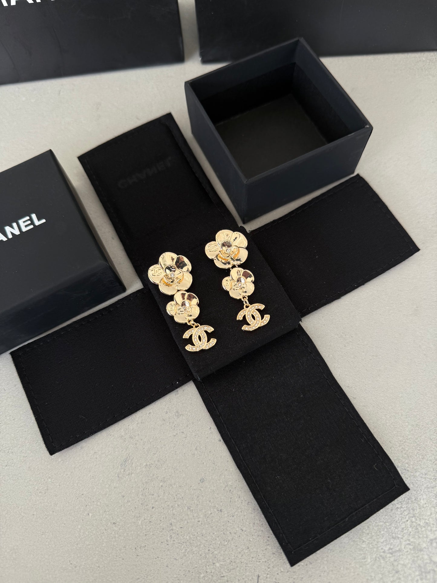 Aretes CC dorados con diseño de flores