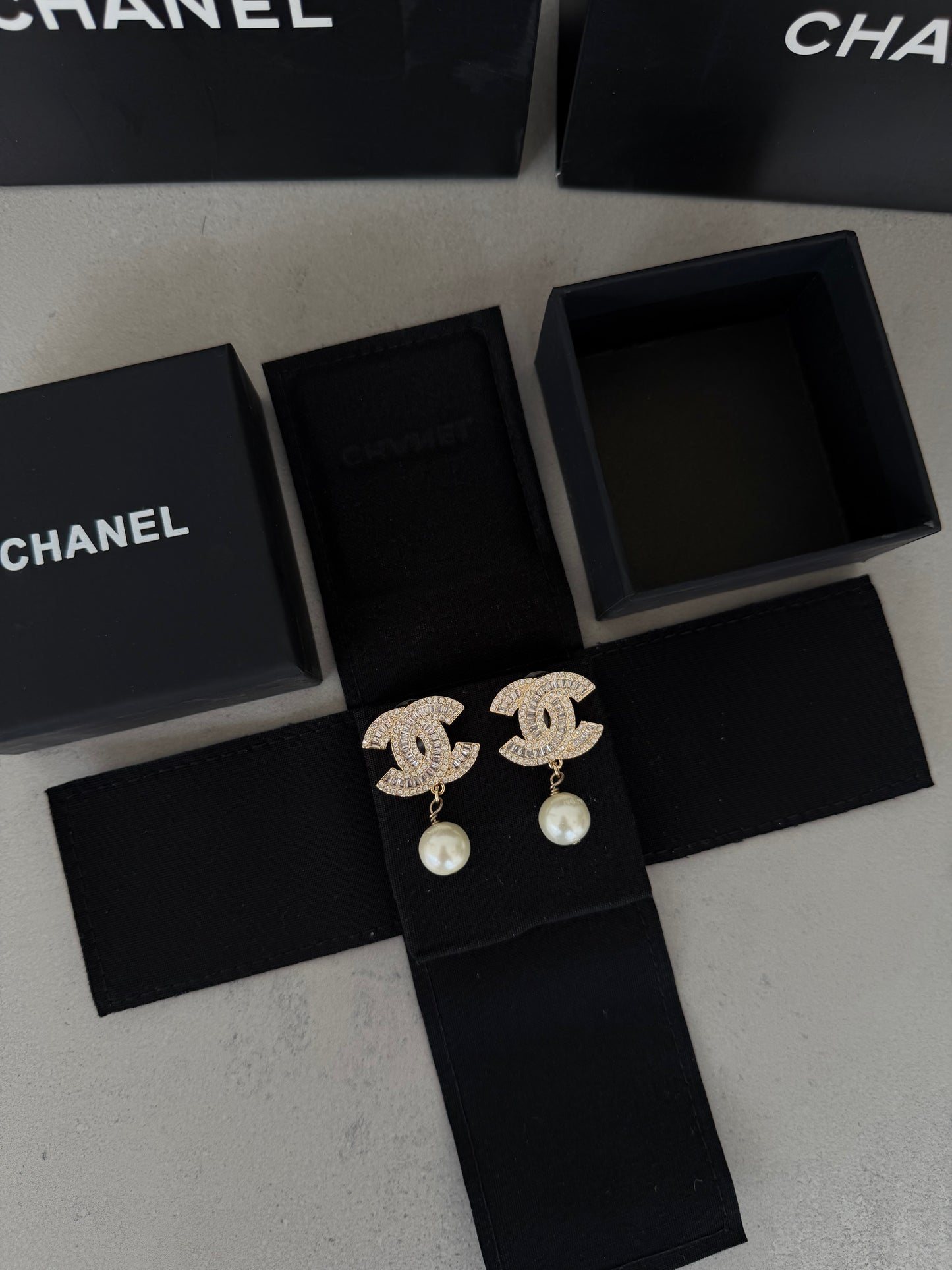 Aretes CC dorados con diamantes y perla colgante