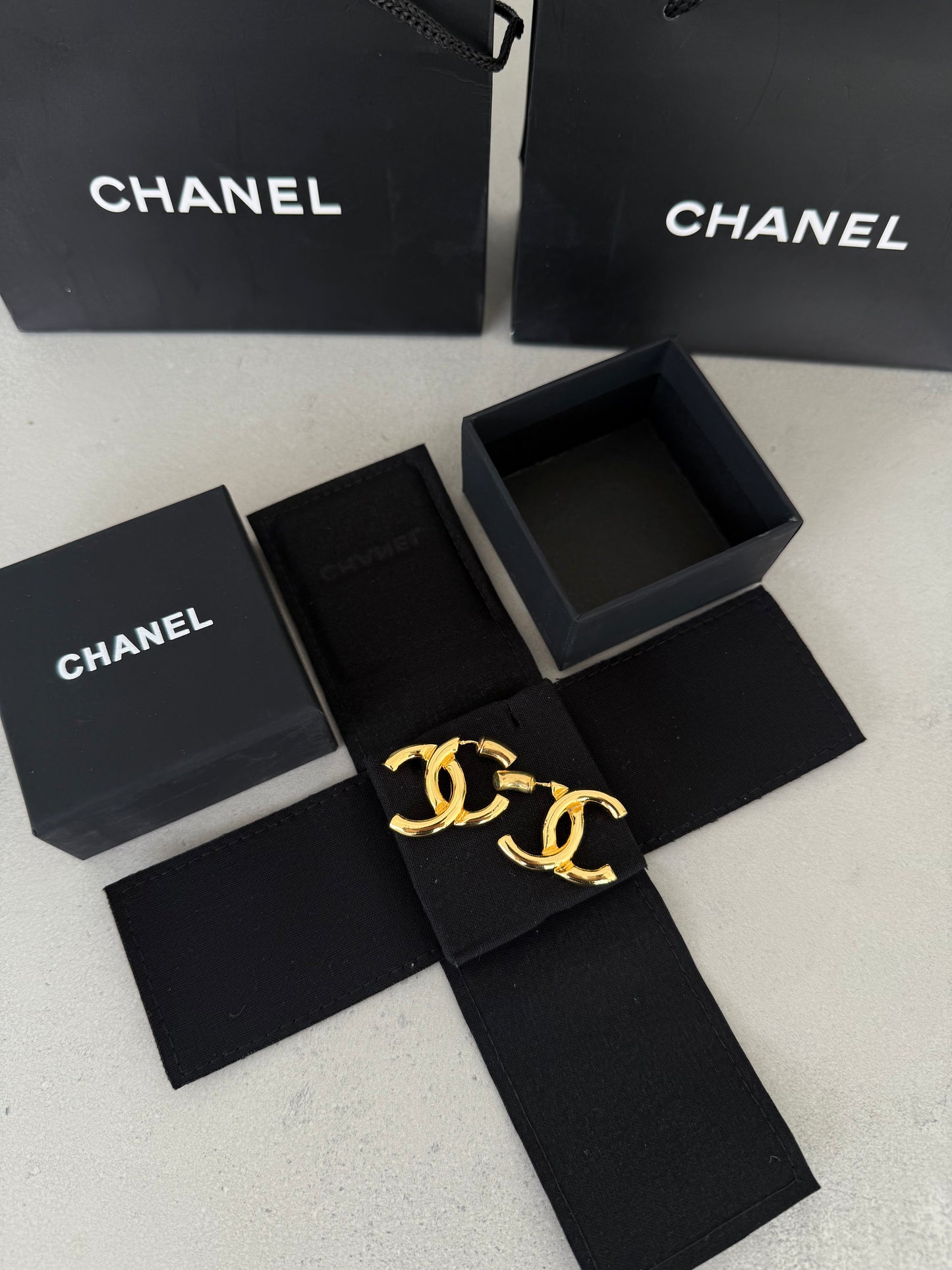 Aretes CC dorados con diseño clásico