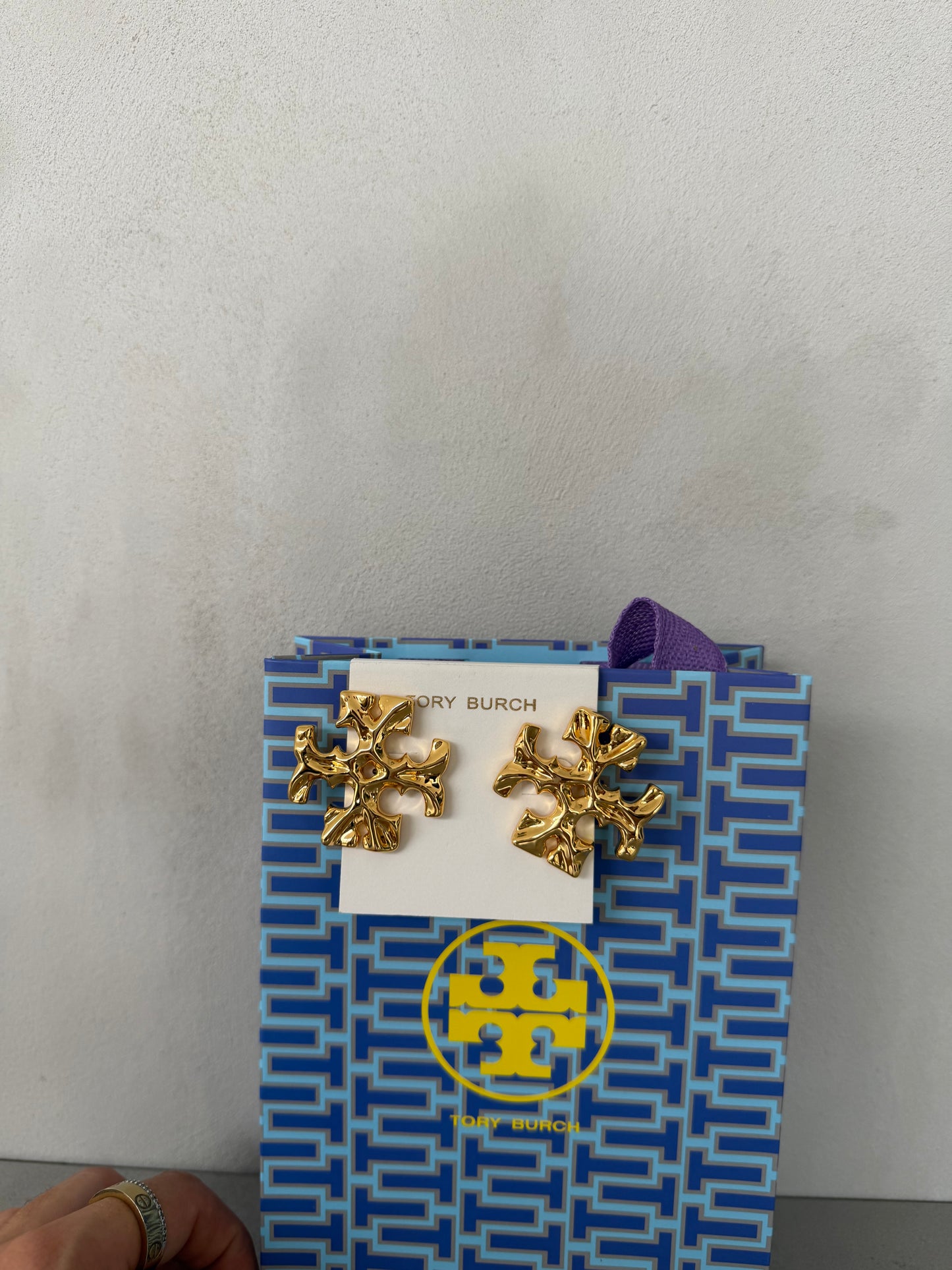 Aretes TB dorados con diseño de logo texturizado