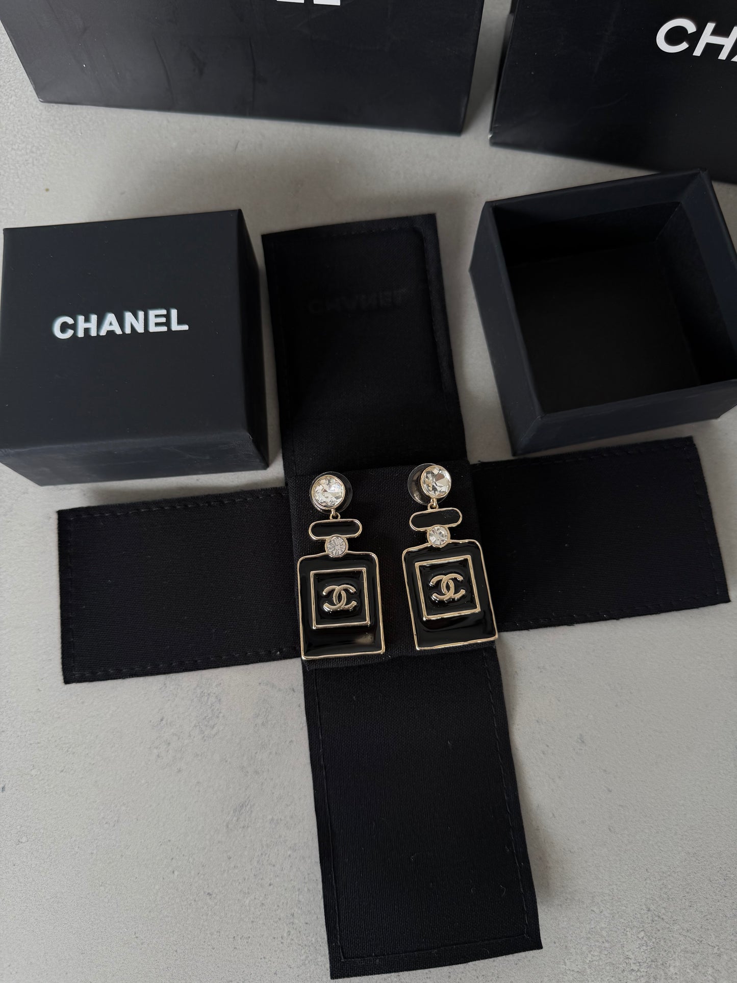 Aretes CC negro y dorado estilo perfume