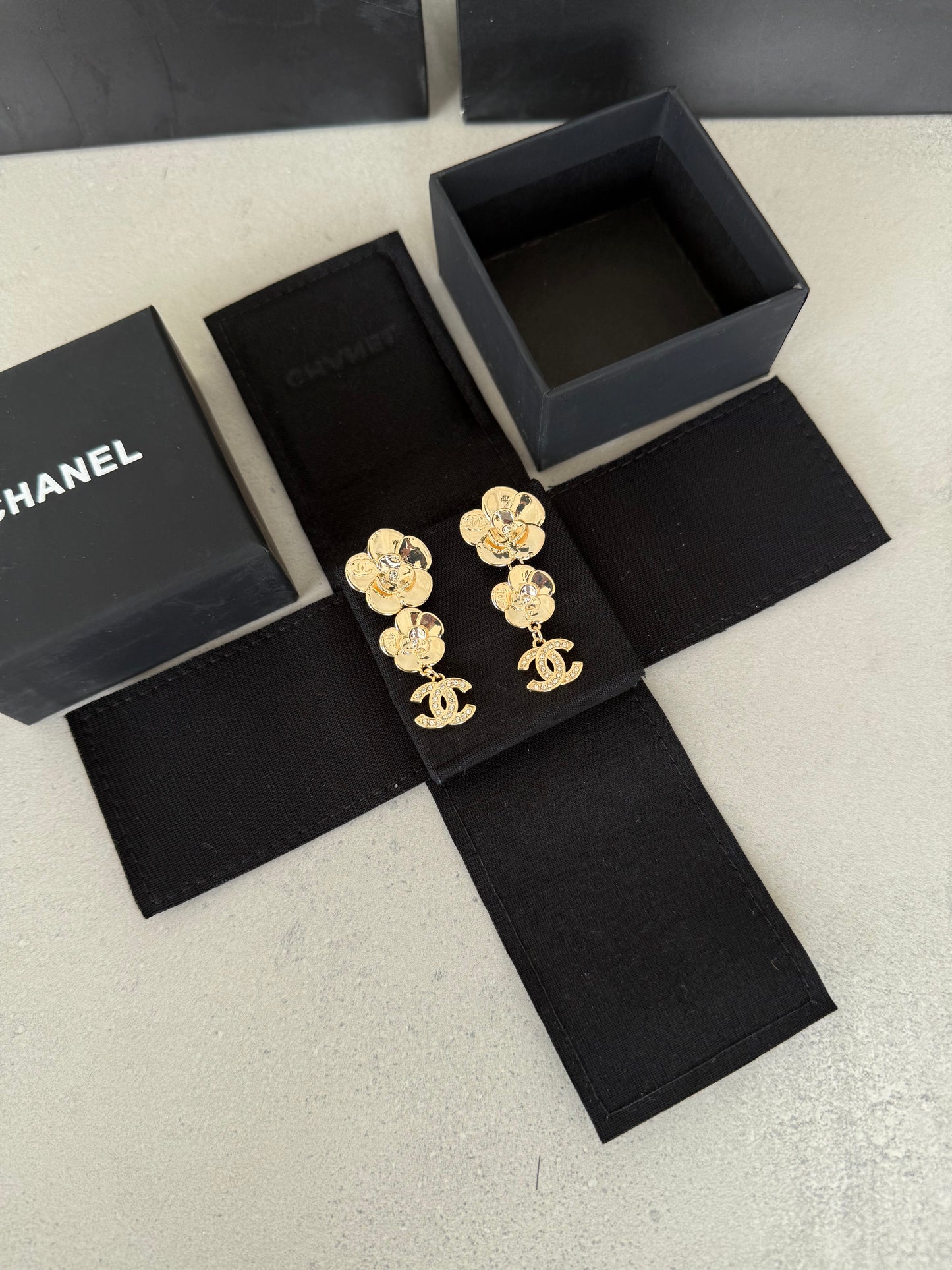 Aretes CC dorados con diseño de flores