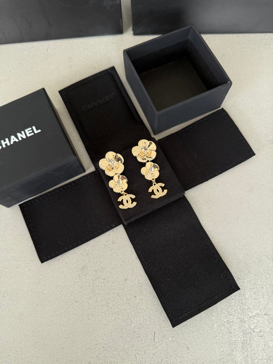 Aretes CC dorados con diseño de flores