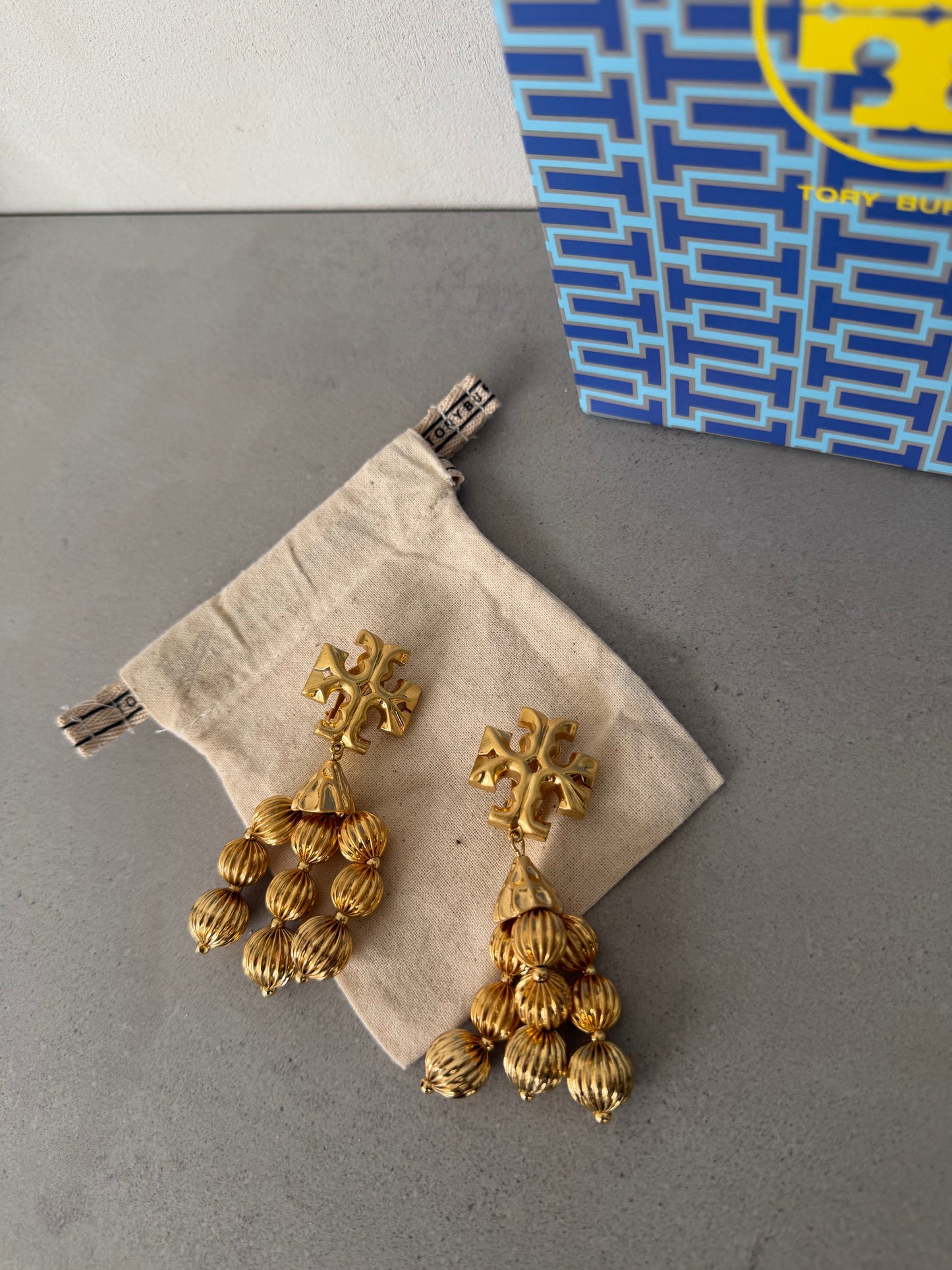 Aretes TB dorados largos con múltiples colgantes texturizados