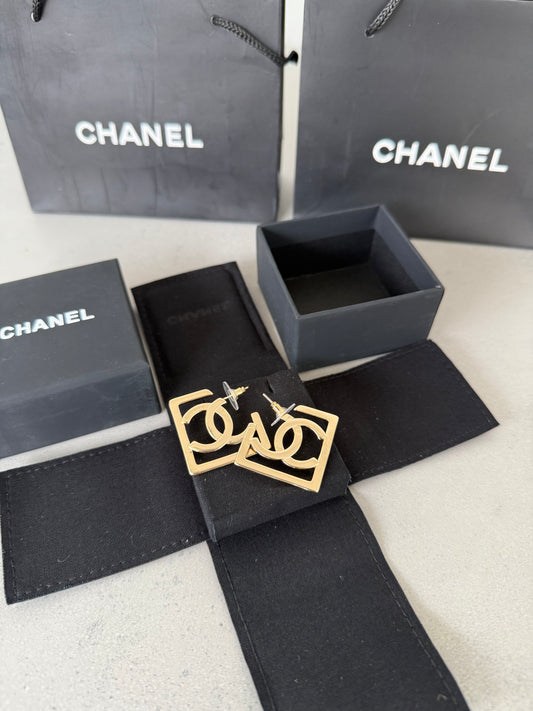 Aretes CC logo dorado en marco geométrico