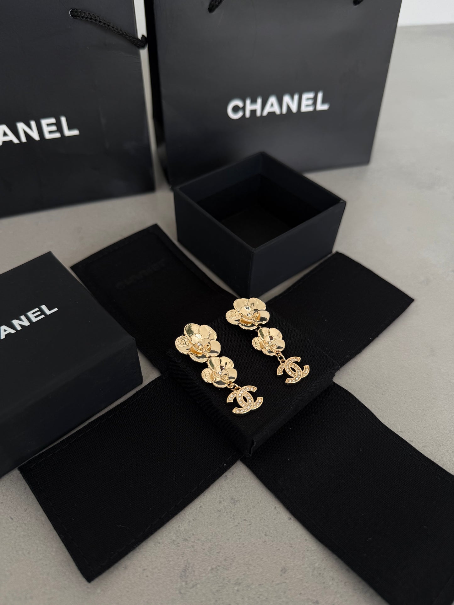 Aretes CC dorados con diseño de flores