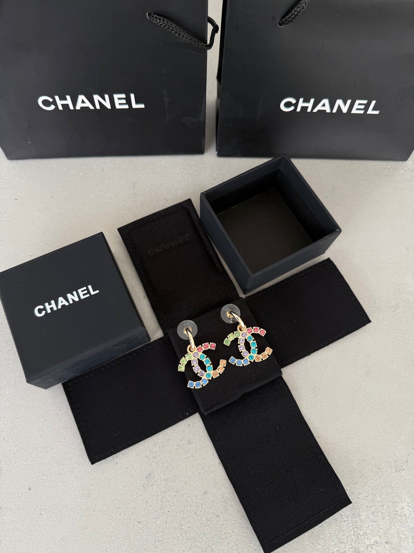 Aretes CC dorados con incrustaciones de colores