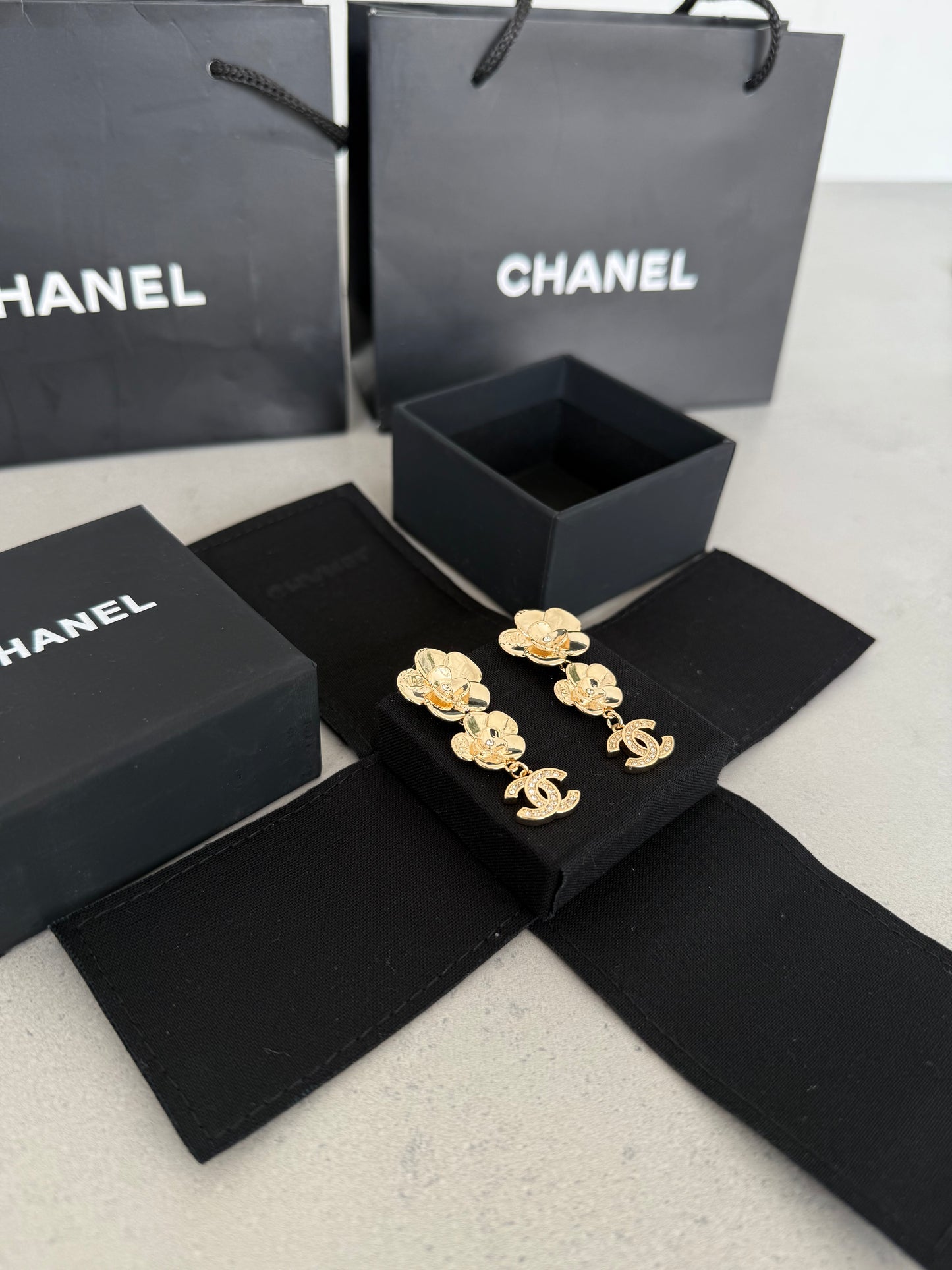 Aretes CC dorados con diseño de flores