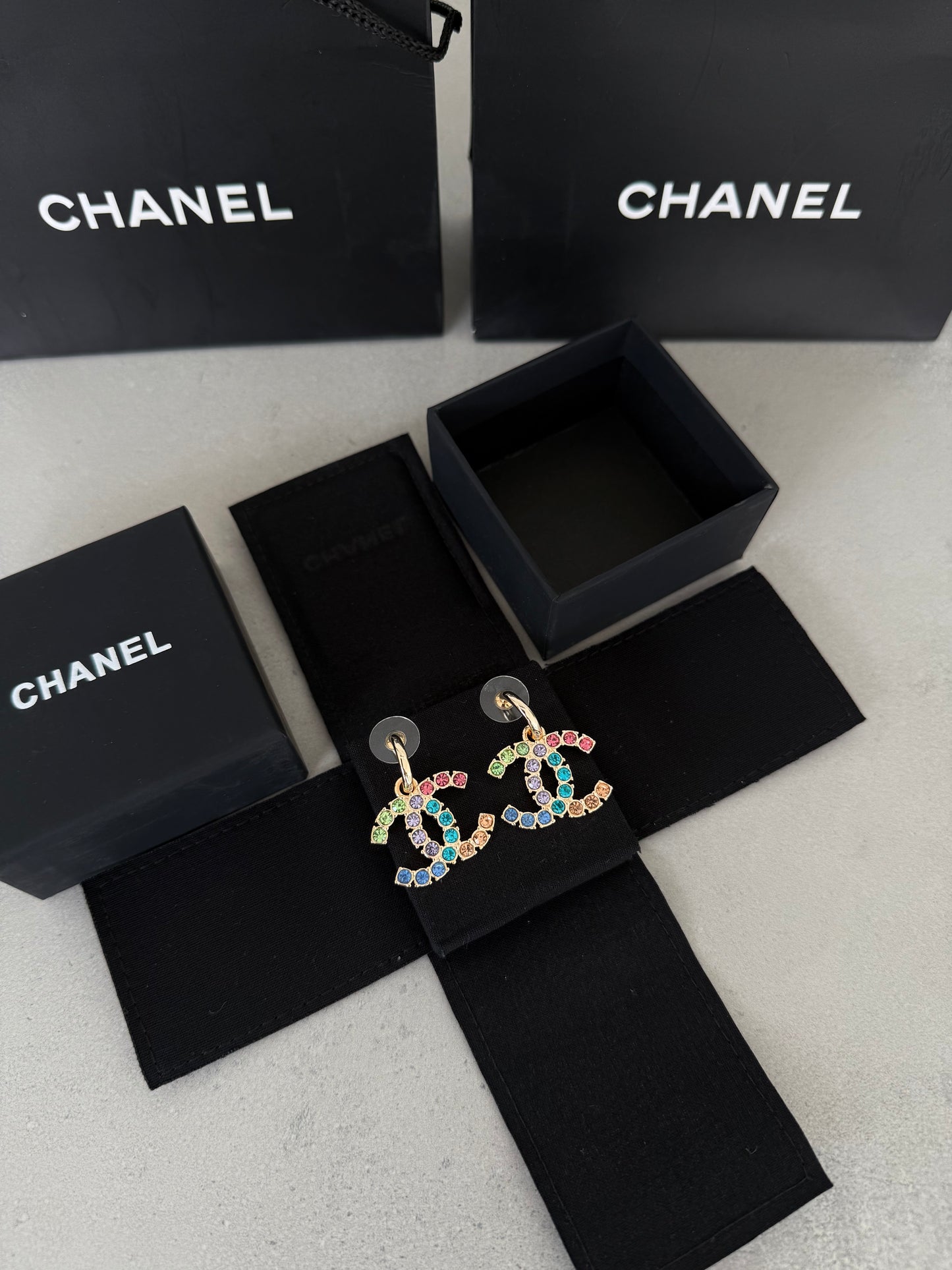 Aretes CC dorados con incrustaciones de colores