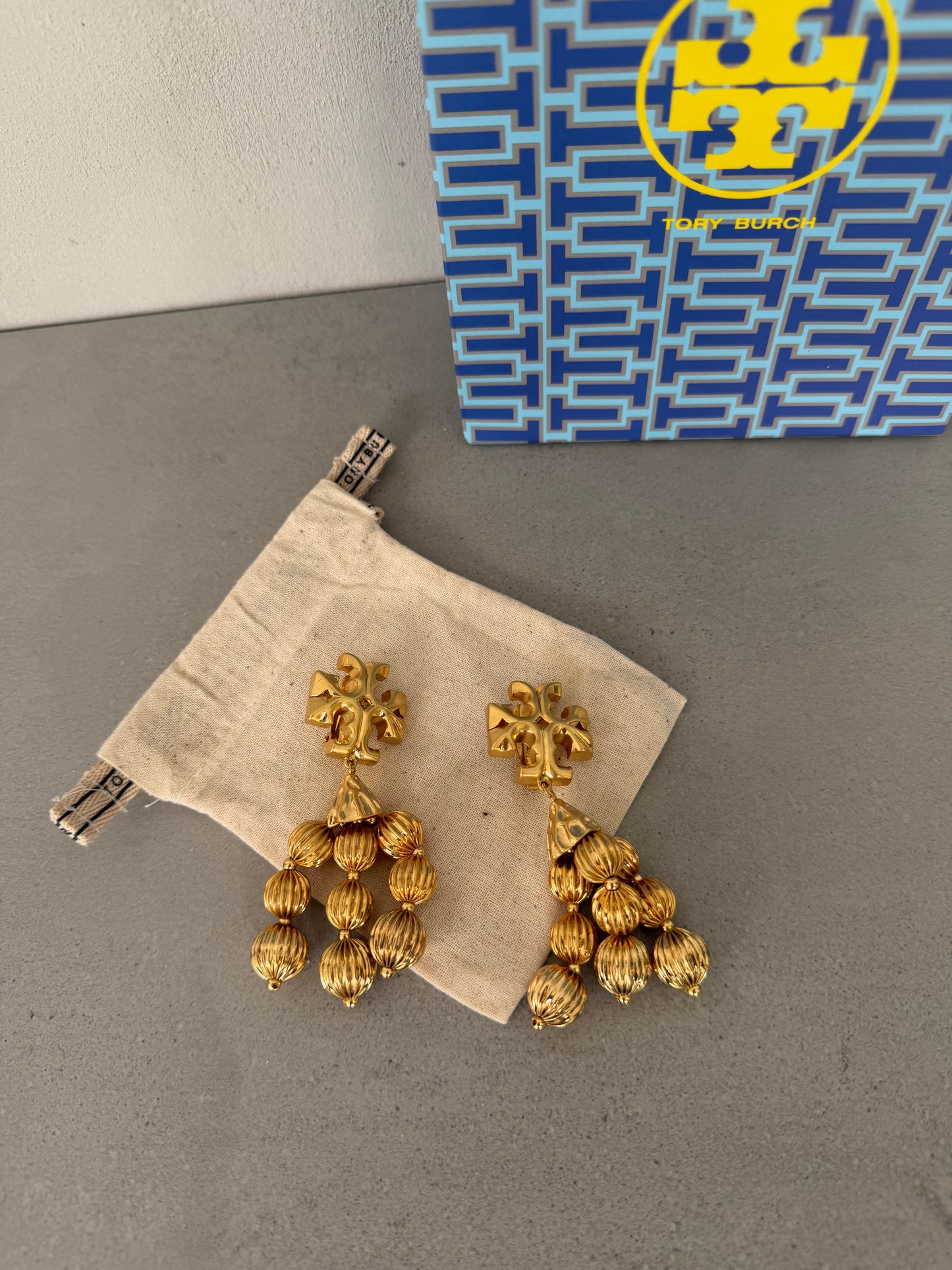 Aretes TB dorados largos con múltiples colgantes texturizados