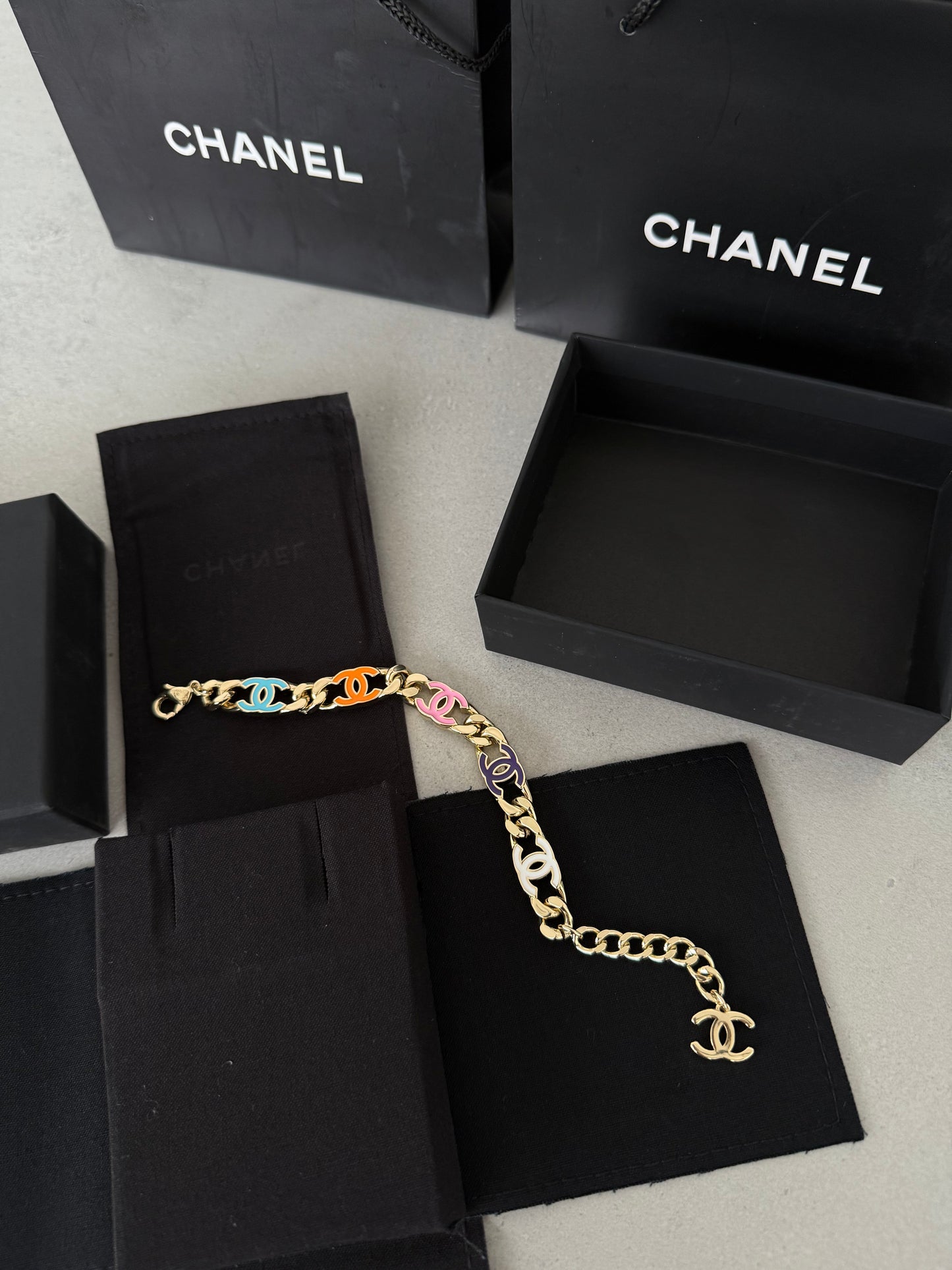 Pulsera CC dorada con logos multicolor