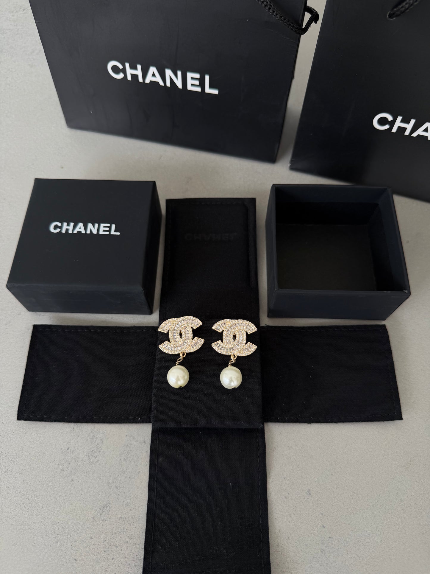 Aretes CC dorados con diamantes y perla colgante