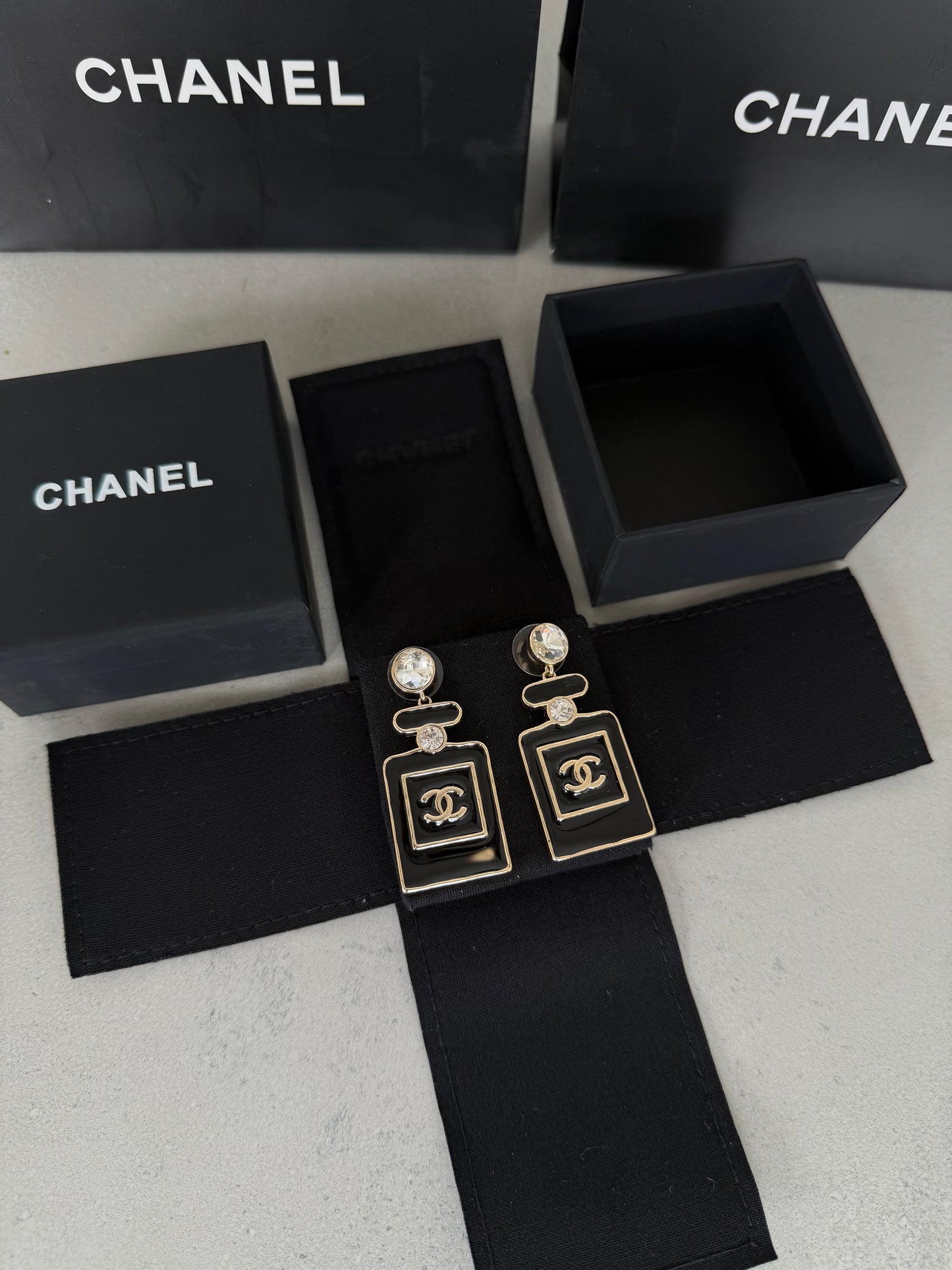 Aretes CC negro y dorado estilo perfume